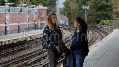 两名年轻女子在伦敦地铁站等地铁